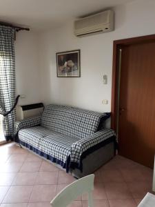 a bedroom with a bed and a window and a fan at Appartamento Ai Tigli in Caorle