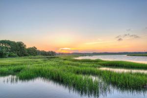 a view of a marsh with the sunset in the background at Saint Andrews Common 1774 in Hilton Head Island