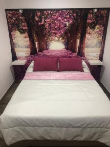 a bedroom with a bed with a painting of a forest at Apartamento de Lola in Setenil