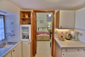 a kitchen with a sink and a room with a bed at 2-level Apartment "Mandraki" in Hydra