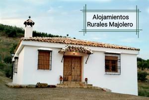 una pequeña casa blanca con una cruz encima en Cortijo Rural Majolero, en Castillo de Locubín