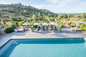 a pool with chairs and umbrellas on a deck at Hotel Les Chambres de Mila Bonifacio in Bonifacio