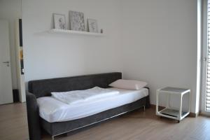 1 dormitorio con 1 cama con sábanas blancas y mesa en Passivhaus Hannover Messe, en Hannover