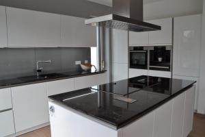 uma cozinha com armários brancos e um balcão preto em Passivhaus Hannover Messe em Hanôver