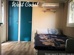 a bedroom with a bed and a blue door at West Coast Mobilhome with XXL Terrace in Naturist Resort Solaris FKK in Poreč