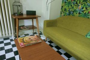 een woonkamer met een bank en een tijdschrift op de vloer bij Le Studio 60' in Mulhouse