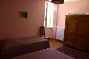 a bedroom with a bed and a dresser and a window at Gîte le Clos de Ceintres in Cheminas