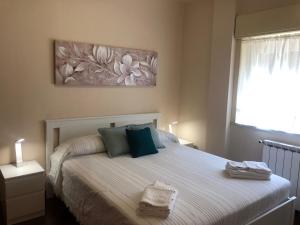 - une chambre avec un lit doté d'oreillers verts et bleus dans l'établissement LA CASA DI ANDREA, à Taormine