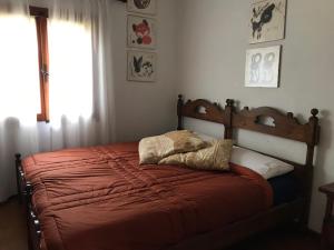 sypialnia z łóżkiem z czerwoną pościelą i oknem w obiekcie Casa Diana w mieście Giannutri