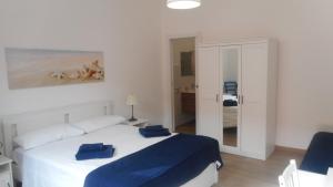 a bedroom with a white bed with blue sheets at Trinacria Bedda in Marzamemi