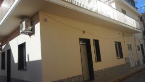 a white building with a door and a balcony at Trinacria Bedda in Marzamemi