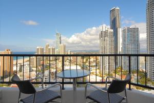a dining room table with a balcony overlooking a city at Mantra on View Hotel in Gold Coast