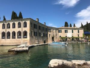 Castelnuovo di Veronaにあるgardaverhuur - La Perla Sul Lagoの水上の船と建物のある川