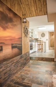 a kitchen with a painting of a pier at Deluxe Rustic Charlestown Themed Apartment in St Austell