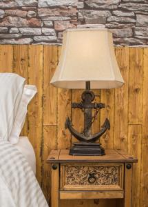 una lámpara en una mesa junto a una cama en Deluxe Rustic Charlestown Themed Apartment en St Austell