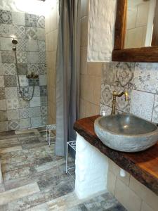 a bathroom with a stone sink and a shower at Trapani glamping camp in Růžová