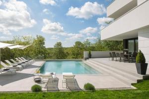 uma piscina com cadeiras e uma casa em Modern Villa 55 with Pool and Spa em Pazin