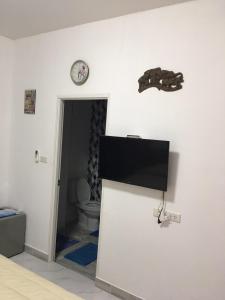 a bathroom with a toilet and a clock on the wall at WaruneeVilla in Nong Prue