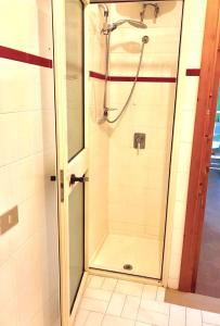 una doccia con porta in vetro in bagno di Apartment Arianna 150mt from beach a Castelsardo