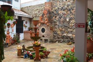 um pátio com uma fonte e um edifício de pedra em Hospedaje El Mirador em Villa de Leyva