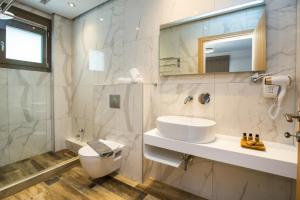 a bathroom with a sink and a toilet and a mirror at Meli Boutique Hotel in Limenaria +56 photos