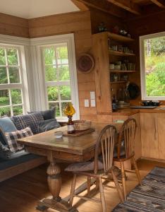 a living room with a wooden table and chairs at Whalers Cottage in Great Barrier Island