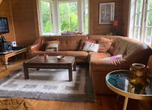 uma sala de estar com um sofá e uma mesa de centro em Whalers Cottage em Great Barrier Island