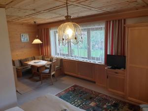 a room with a table and a chandelier and a bedroom at S'Hoamatl in Hofen