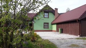 a green and red building with a red roof at Dach Pod Sową in Ludwikowice Kłodzkie