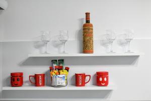 ein Regal mit Gläsern und einer Flasche Wein in der Unterkunft Apartman DMD in Trebinje