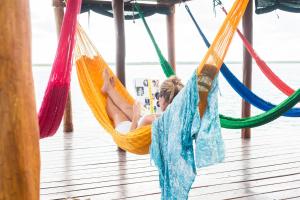 a woman lying in a hammock reading a magazine at Casa Lamat in Bacalar