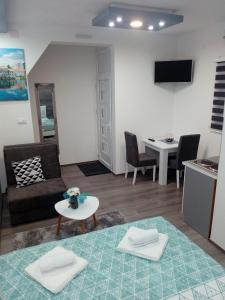 ein Wohnzimmer mit einem Sofa und einem Tisch in der Unterkunft Apartman DMD in Trebinje