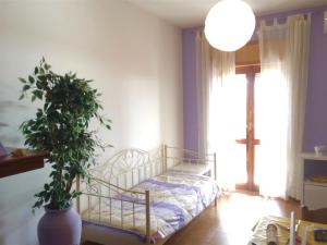 sypialnia z łóżkiem i doniczką w obiekcie Apartment Arianna 150mt from beach w mieście Castelsardo