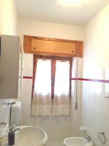 bagno con lavandino e finestra di Apartment Arianna 150mt from beach a Castelsardo