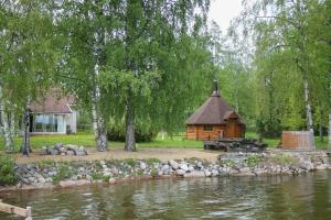 domek z bali obok rzeki z budynkiem w obiekcie Lake Suite w mieście Lahti