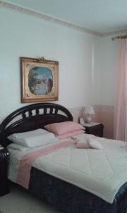 una camera con un letto con una foto sul muro di Villa Stabile relax a Guarrato