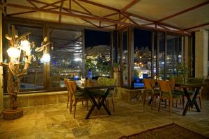 a dining room with a table and chairs and a window at Feel Cappadocia Stone House in Göreme