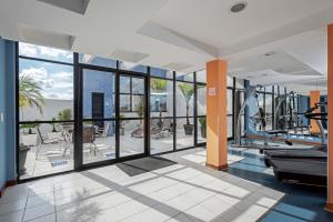 une salle de sport vide avec des équipements de sport et des portes en verre dans l'établissement Slaviero Curitiba Batel, à Curitiba