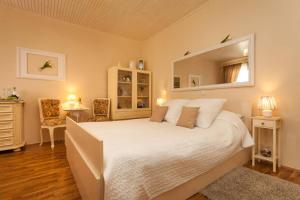 una camera da letto con un grande letto bianco e uno specchio di Apartment City Center Amaryllis a Rovigno (Rovinj)