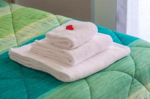a pile of towels sitting on top of a bed at Melo Accommodations in Bari