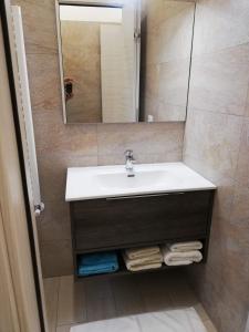 uma casa de banho com um lavatório e um espelho em Rogoredo Milan Apartments em Milão