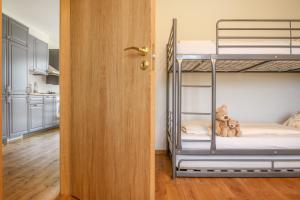 ニダにあるKopu Vetrunges - Nida Apartmentsの二段ベッド2台とドアが備わる客室です。