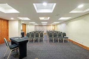 une salle de conférence avec une rangée de chaises et un podium dans l'établissement Slaviero Curitiba Batel, à Curitiba