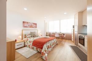 a bedroom with a bed and a table with chairs at Avenida apartment 1,2 e 3 in Braga