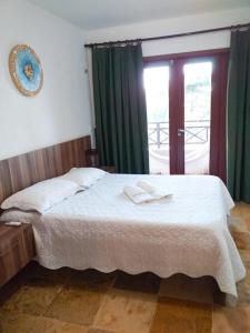 una camera da letto con un letto grande con tende verdi di Wind Villa Cumbuco - Apartamento a Cumbuco