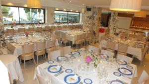 a banquet hall with tables and chairs with white tablecloths at Canyelles Platja in Roses +37 photos