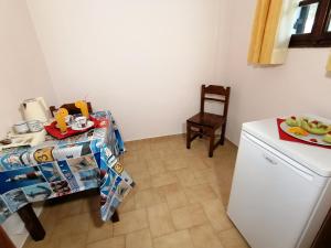 a small kitchen with a table and a refrigerator at Vasilaras Hotel in Skala