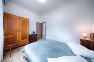 a bedroom with a bed and a wooden cabinet at Seaview apartment Bambo in Komiža