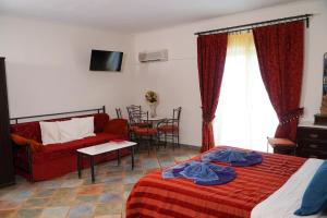 a bedroom with a bed and a couch and a table at Vasilaras Hotel in Skala