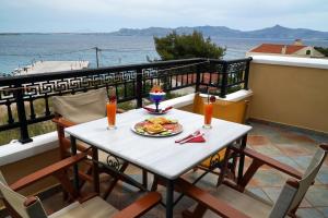 a table with a plate of food on a balcony at Vasilaras Hotel in Skala